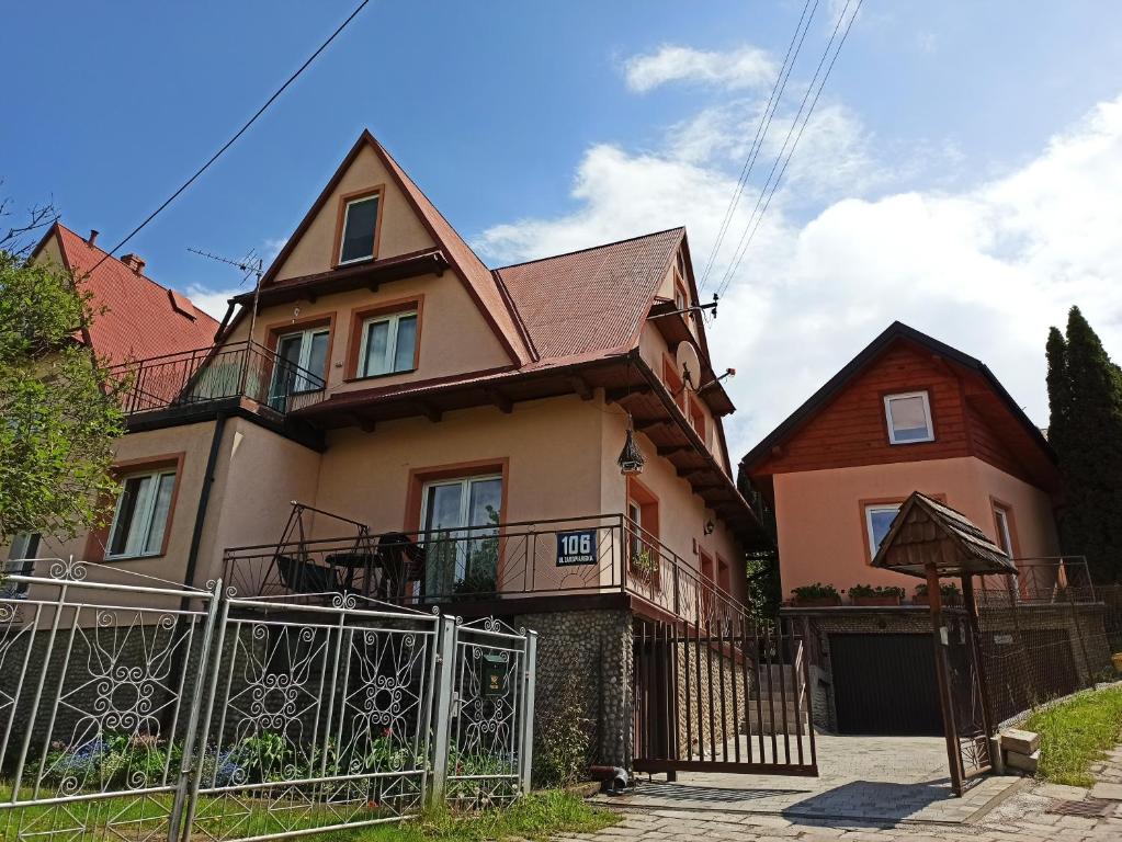 dom z płotem przed nim w obiekcie Apartament-studio, pokoje u Lucy w Rabce