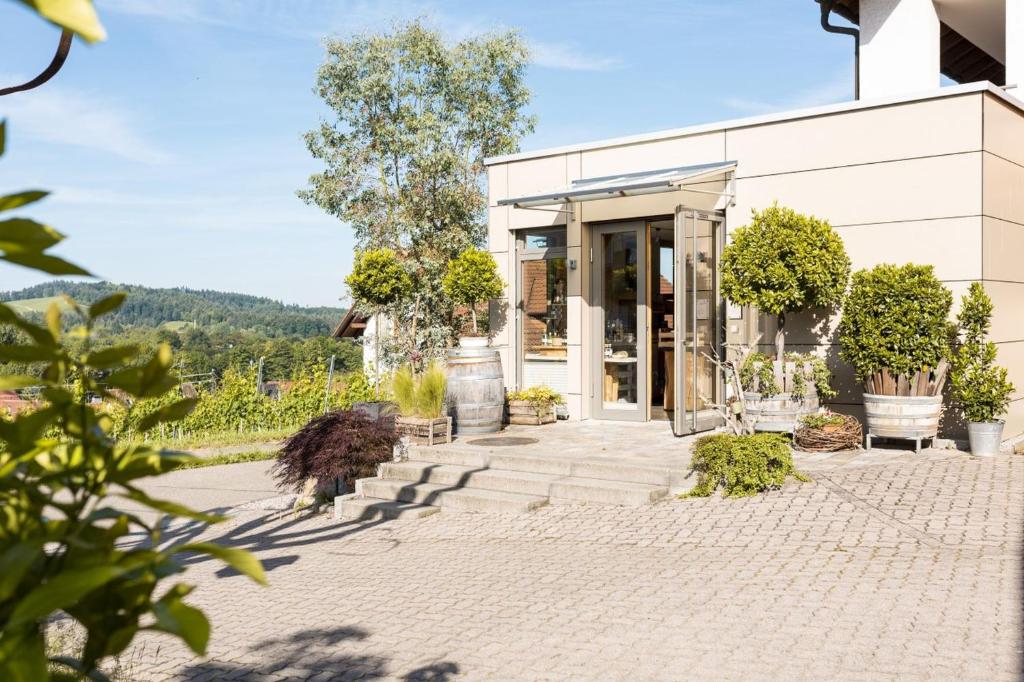 une maison blanche avec une terrasse ornée de plantes dans l'établissement Kohler Hofquartier, à Kappelrodeck