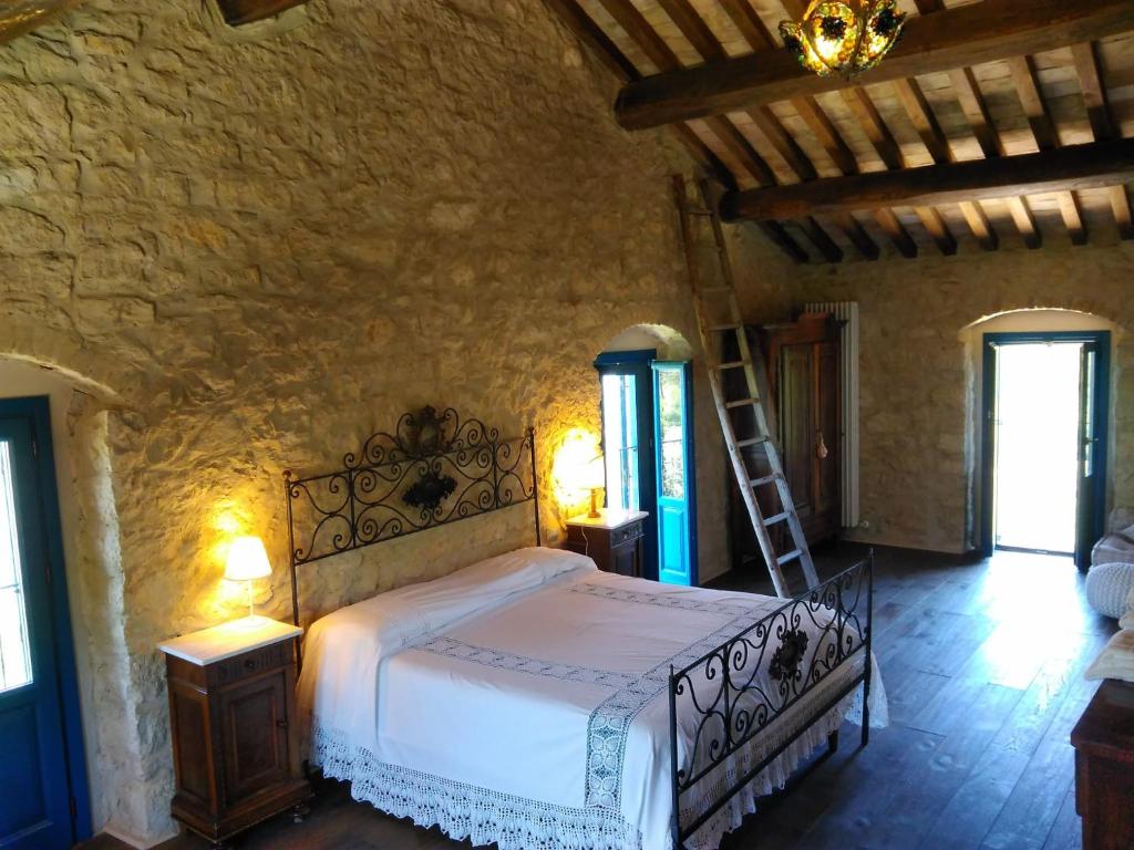 a bedroom with a bed in a stone wall at La casa dalle finestre blu in Abbateggio