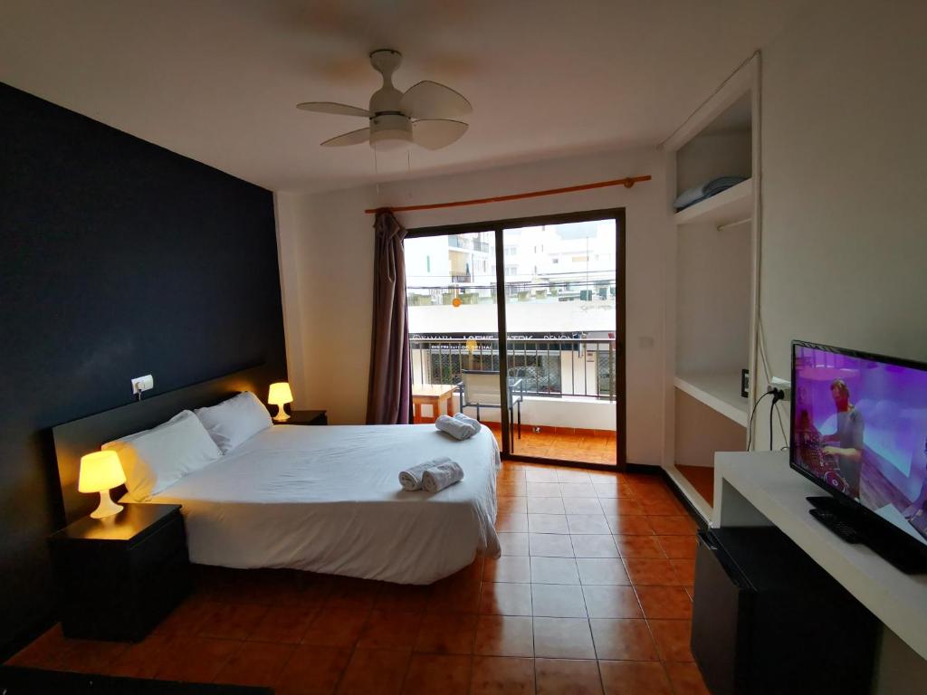 a hotel room with a bed and a television at Hostal Baleàric in San Antonio