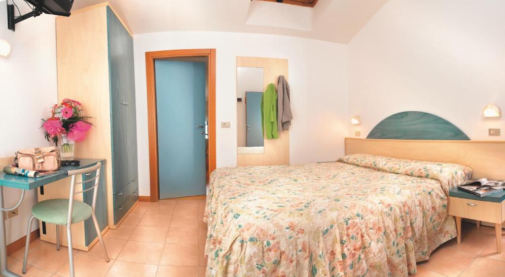 ベッラーリア・イジェア・マリーナにあるHotel Villa Rossiのベッド、テーブル、椅子が備わるホテルルームです。