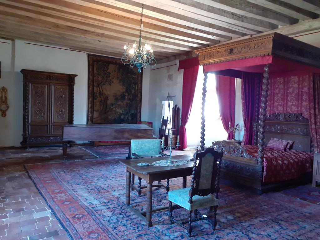 a living room with a bed and a table at Chateau de Chémery in Chémery