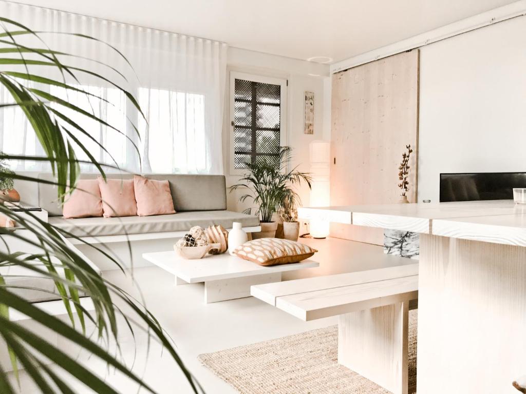 sala de estar con muebles blancos y almohadas rosas en Casasuul Alvor, en Alvor