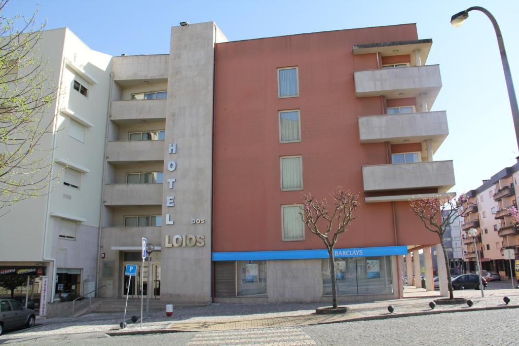 a red building on a street in a city at Hotel dos Loios in Santa Maria da Feira