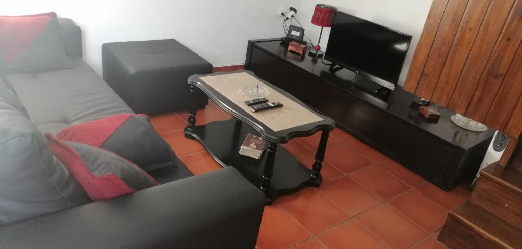 a living room with a tv and a table at Casa Dos Mosteiros in Mosteiros