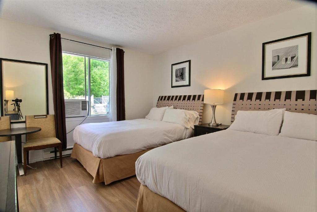 a hotel room with two beds and a window at Motel de la montagne Orford in Orford