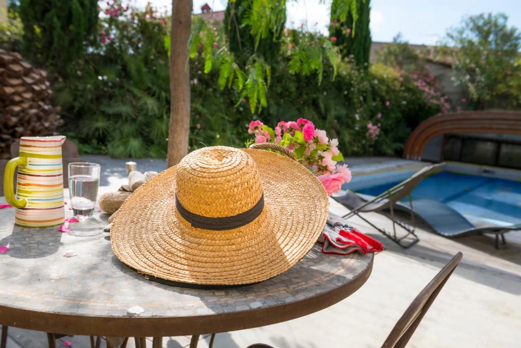 un chapeau en paille assis au-dessus d'une table dans l'établissement La Villa ioanes, à Port-Saint-Louis-du-Rhône
