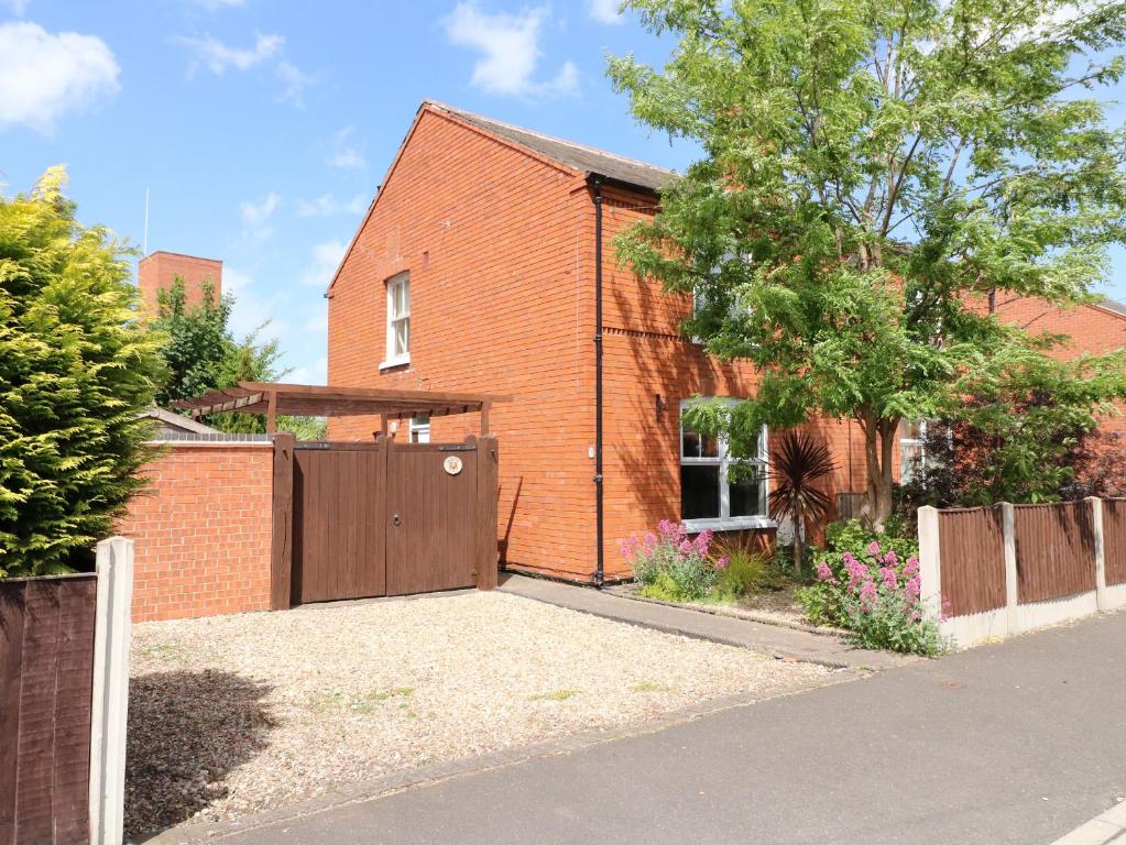 a brick house with a gate and a fence at Cherry Lodge in Newark-on-Trent