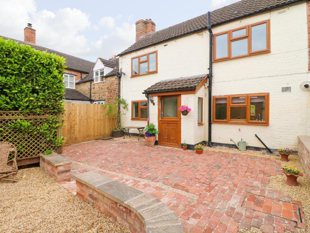 un patio de ladrillo frente a una casa en Bennett's Cottage en Oakham