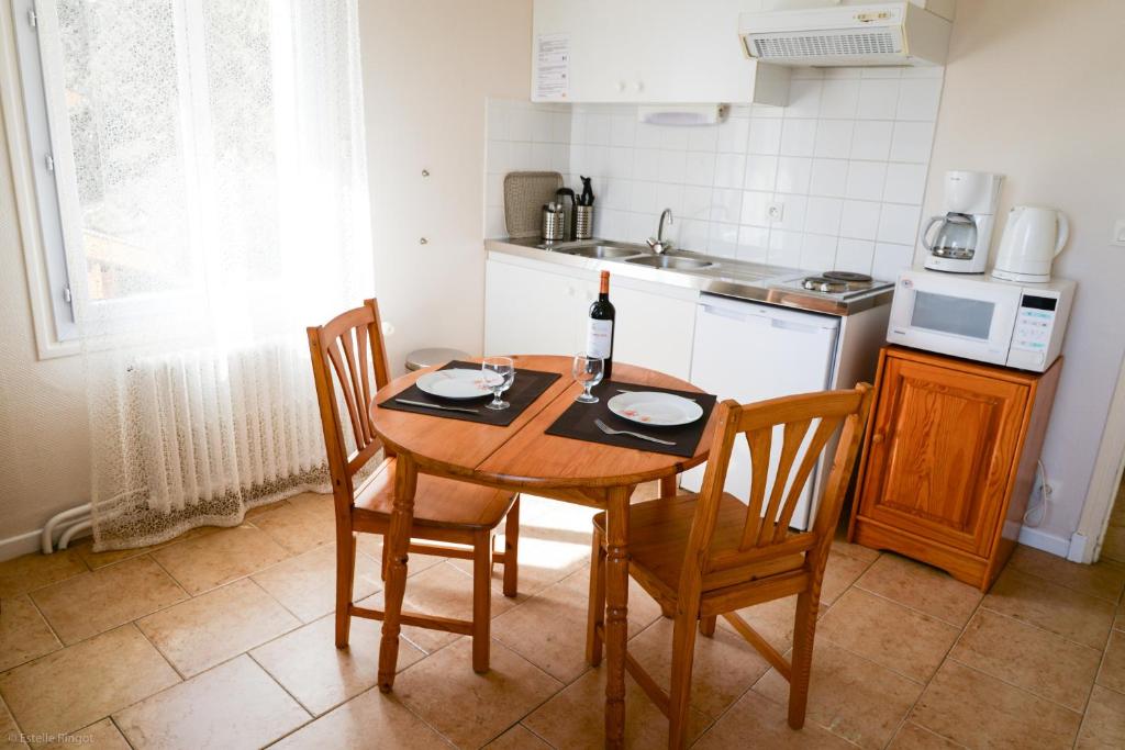 cocina con mesa y botella de vino en Residence Les Cimes, en Font-Romeu