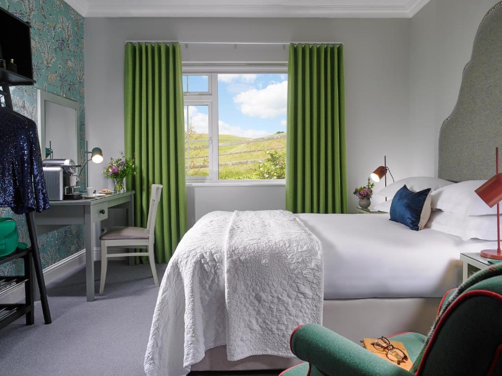 a bedroom with a bed and a desk and a window at Dunmore House Hotel in Clonakilty