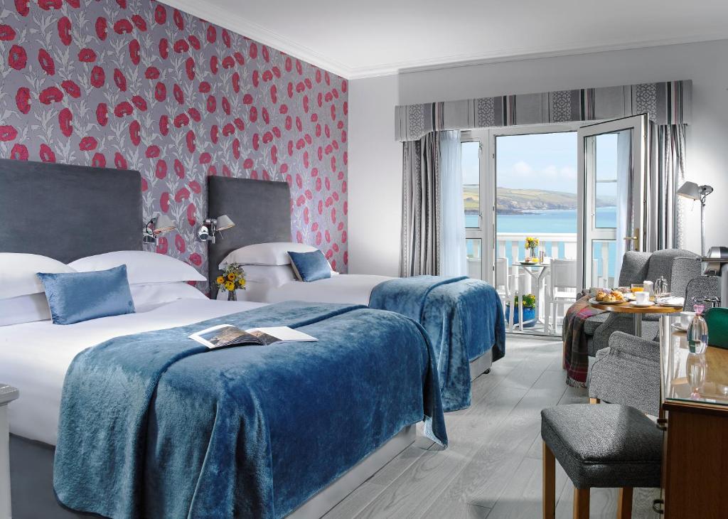 a hotel room with two beds with blue sheets at Dunmore House Hotel in Clonakilty