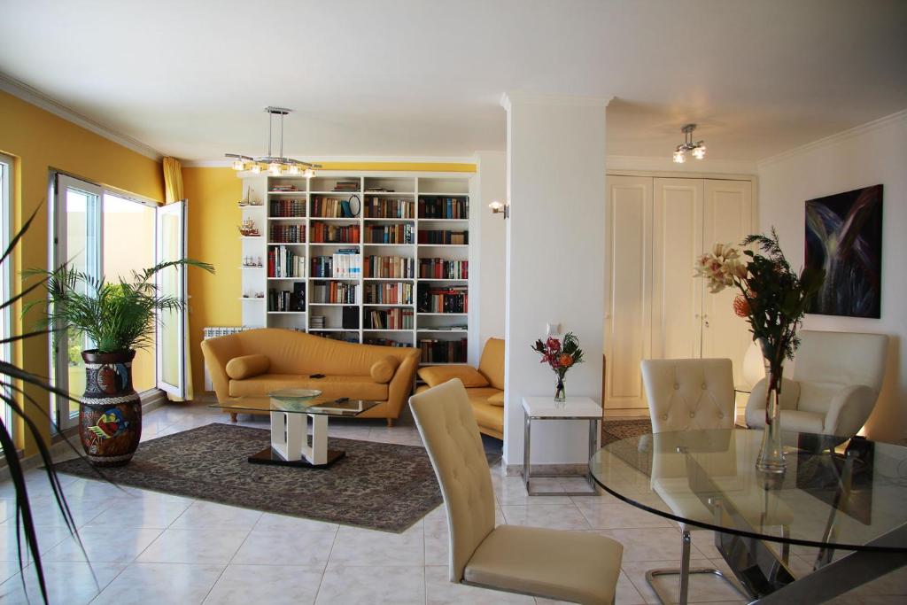 un salon avec un canapé et une table en verre dans l'établissement Villa Erika Madeira -Penthaus-, à Caniço