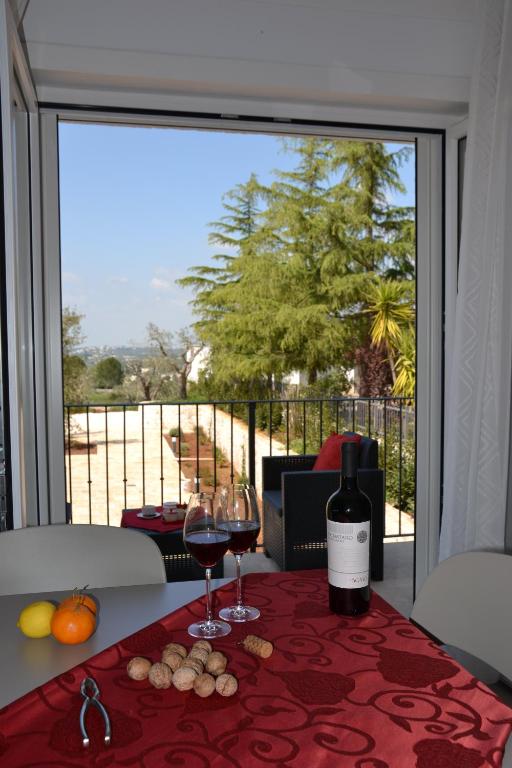 une table avec deux verres de vin assis sur une table dans l'établissement Il Tramonto Apartment - Villaggio di Mary, à Locorotondo