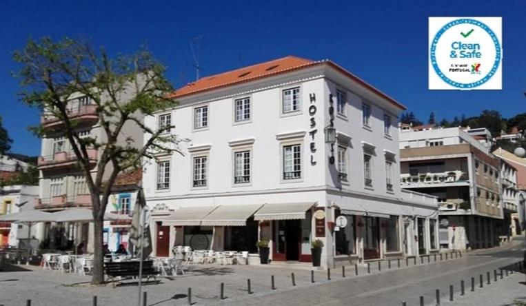 a large white building on the side of a street at Hostel Rossio Alcobaça in Alcobaça