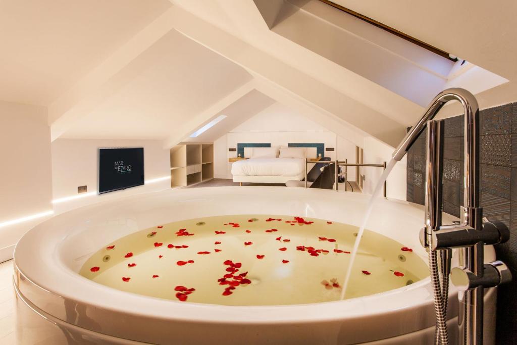 a bathroom with a bath tub with flowers on the floor at Mar do Ézaro - Boutique Hotel in Ézaro