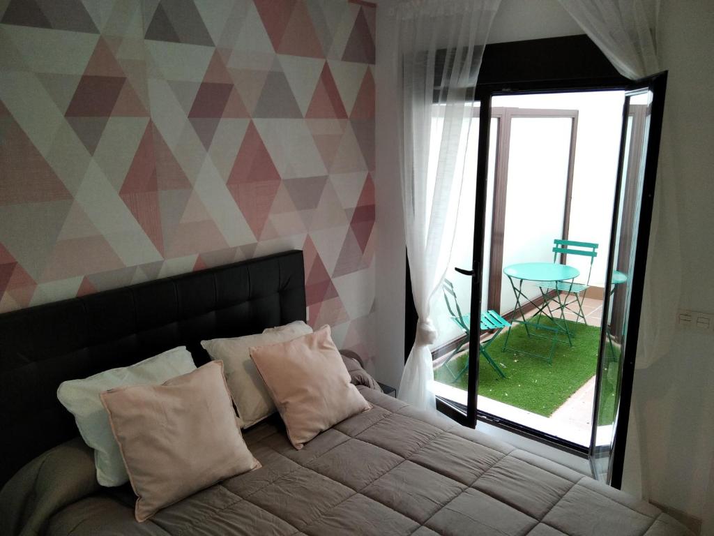 a bedroom with a bed with a view of a patio at Apto la Venta-CON PARKING GRATIS in Toledo