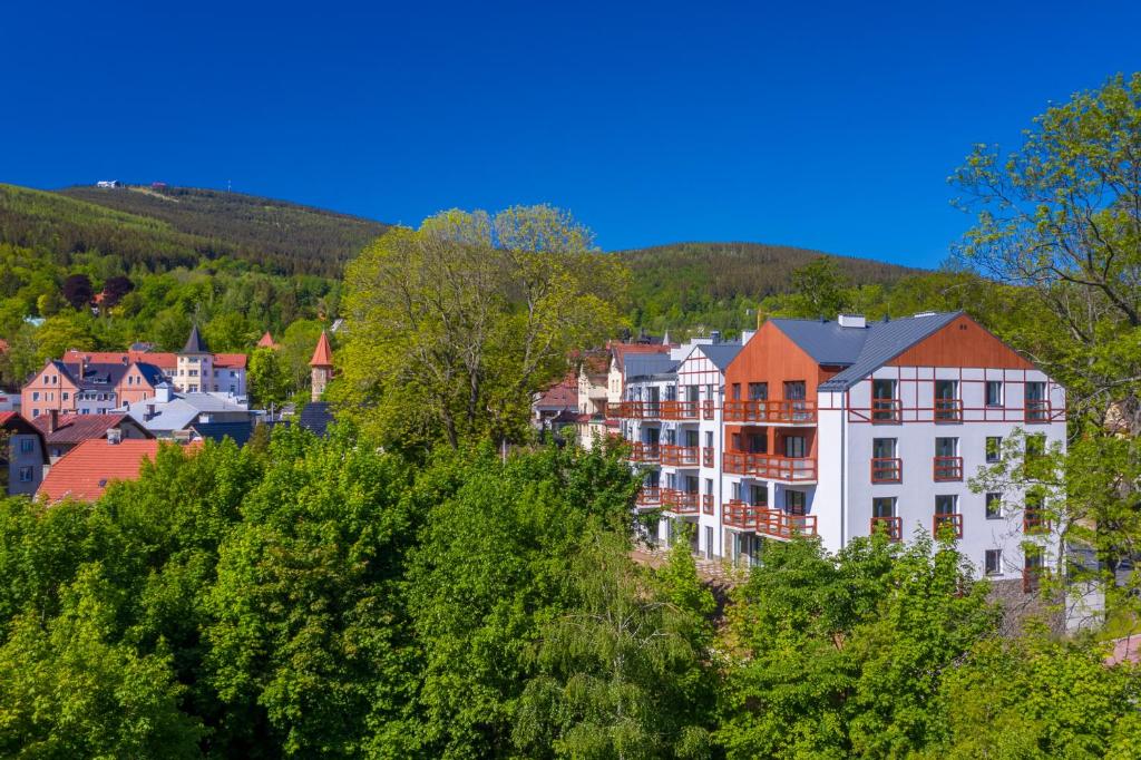 a group of buildings on a hill with trees at Apartamenty Holiday Mountain Residence by Royal Aparts in Świeradów-Zdrój