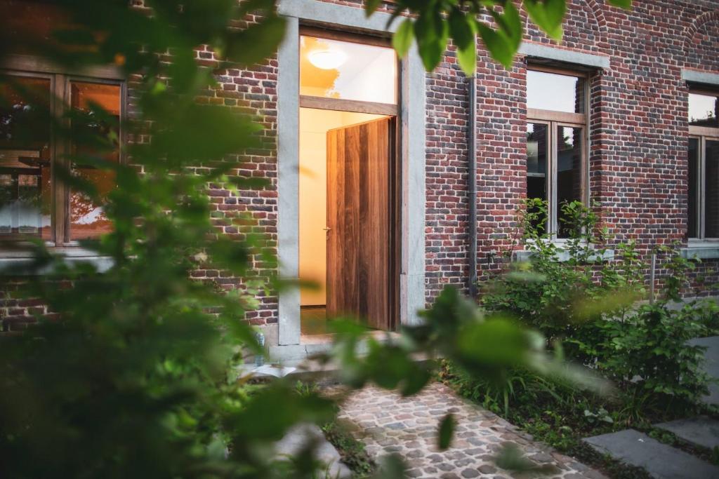 una puerta de madera en un edificio de ladrillo en Sint Jacobshoeve, en Oudenaarde