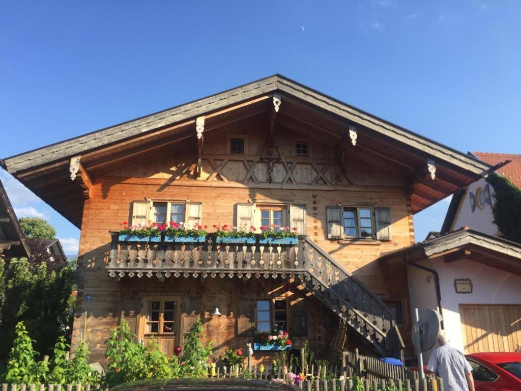 una casa de madera con un balcón con flores. en Blockhaus-Traum Huber en Garmisch-Partenkirchen