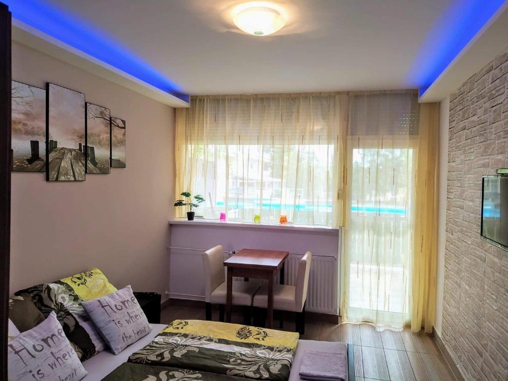 a room with a couch and a table and a window at Mira Apartman in Keszthely