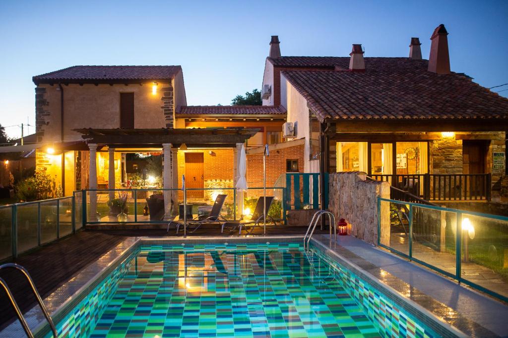 una casa con piscina frente a una casa en Hotel Rural El Tejar de Miro, en Ceadea