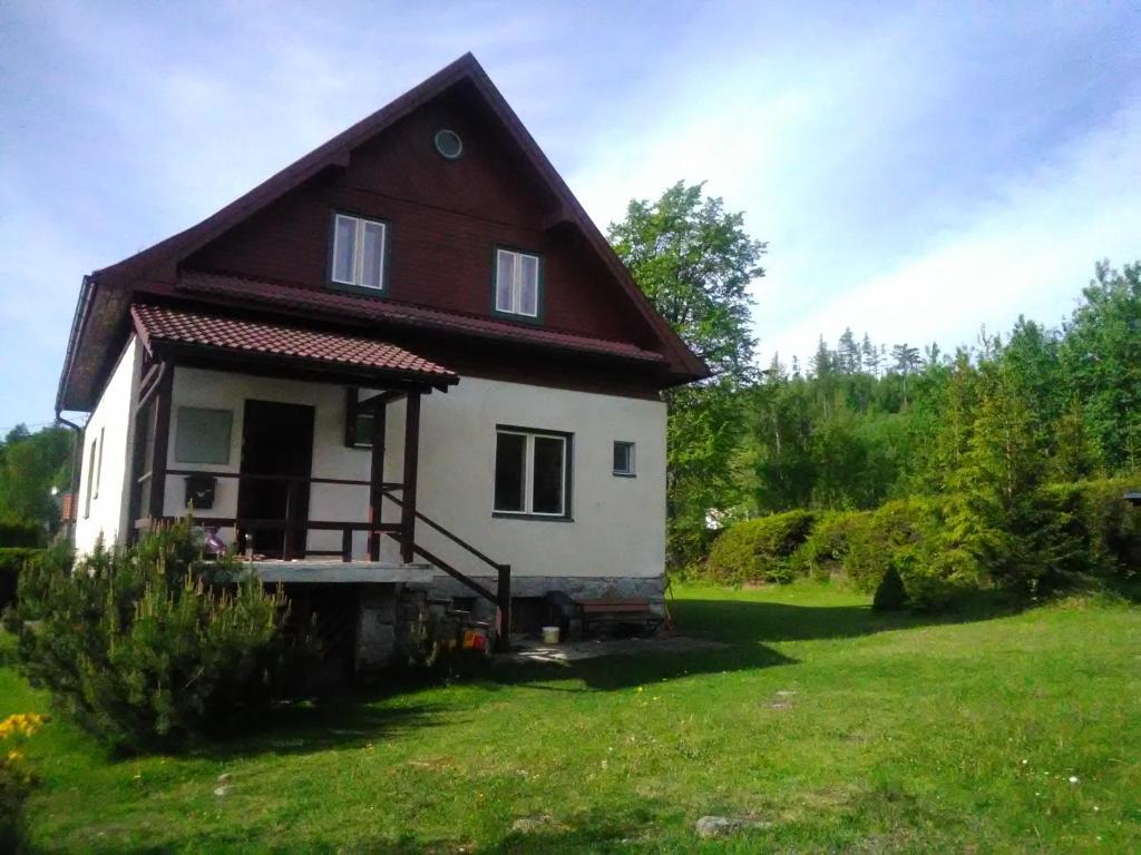 a small house in a field with a yard at Villa Ester in Tatranská Lomnica