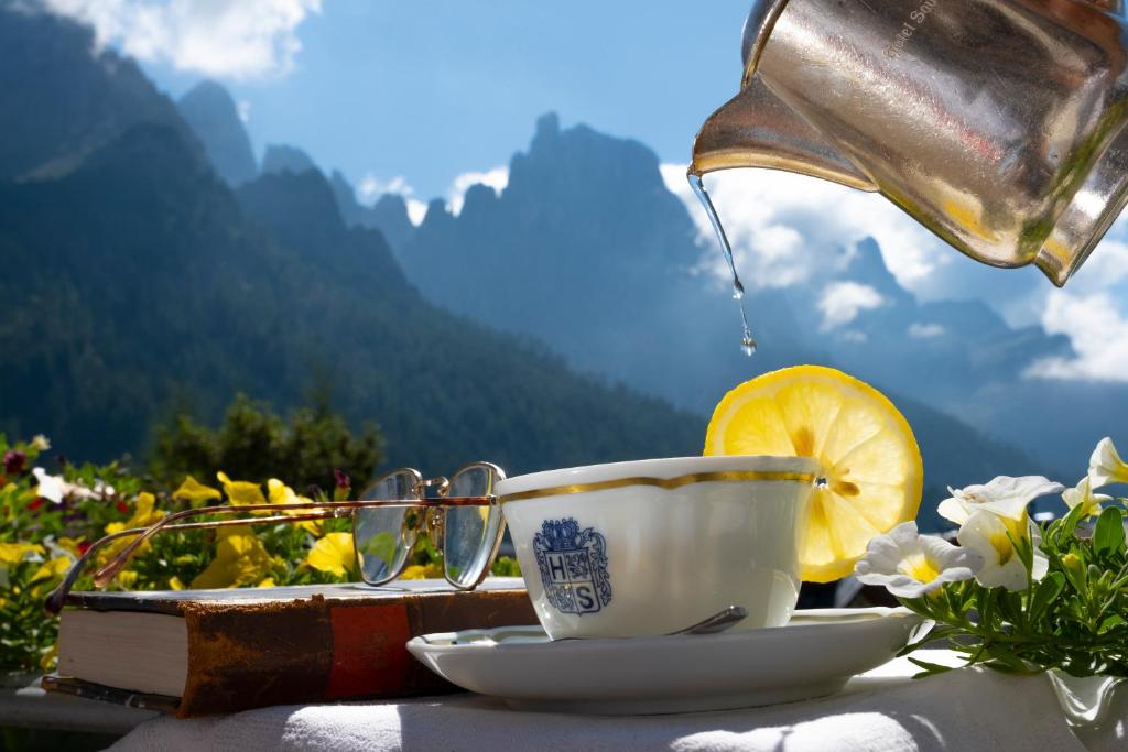 a cup of tea and a lemon on a table at Hotel Savoia dal 1924 in San Martino di Castrozza