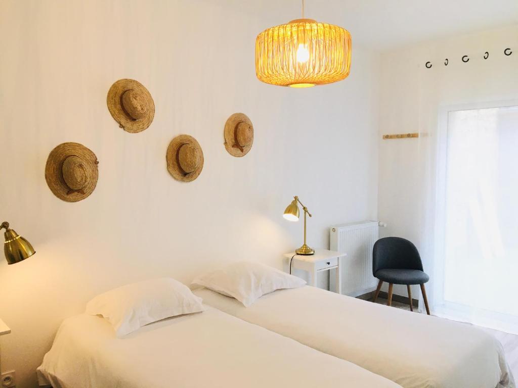 two beds in a bedroom with hats on the wall at Hotel Saint-Michel in Dinard