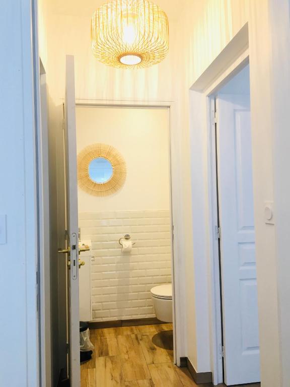 a bathroom with a toilet and a chandelier at Hotel Saint-Michel in Dinard