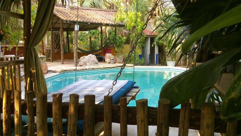 un columpio junto a una piscina en un patio en Posada El Jardin, en Ticul