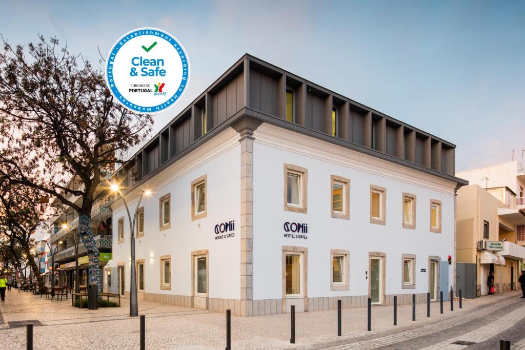 a white building with a sign that says clean and safe at Hostel Conii & Suites Algarve in Quarteira