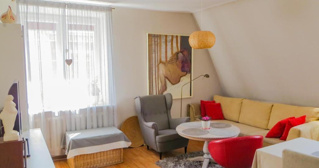 ein Wohnzimmer mit einem Sofa, einem Tisch und Stühlen in der Unterkunft Hello Apartments COZY & ART VIBES Targ Rybny in Danzig