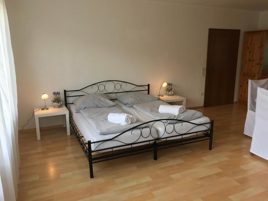 um quarto com uma cama preta e duas mesas em Gästehaus Steinmann Apartment 2 Zimmer em Miltenberg