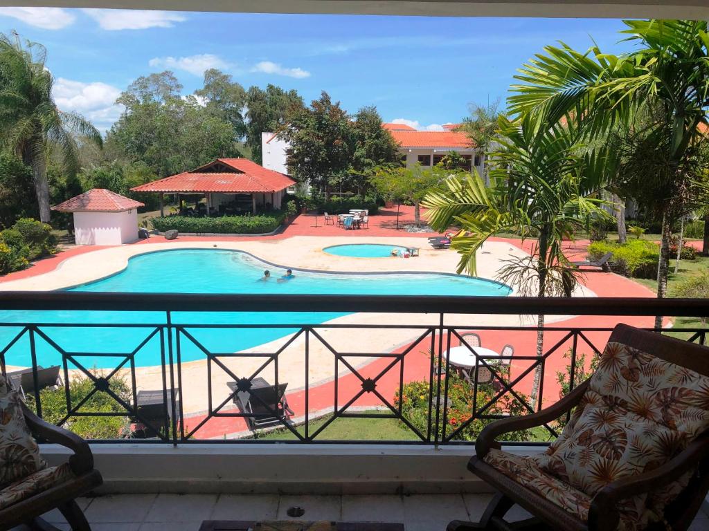 balkon z widokiem na basen w obiekcie Los Corozos Apartment A2 Guavaberry Golf and Country Club w mieście Juan Dolio