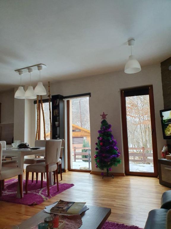 a living room with a christmas tree and a table at Lodge Zeleni svet in Crni Vrh