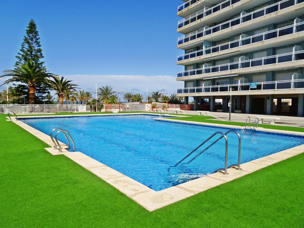 una grande piscina di fronte a un edificio di AIGUA BLAVA Primera línea - Alquiler solo familias a Playa de Gandia