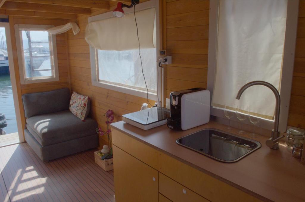 a kitchen with a sink and a chair next to a window at HouseBoat Cagliari in Cagliari