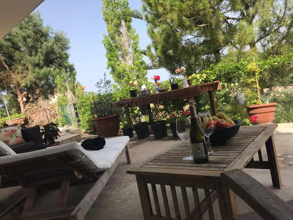 a table with a bottle of wine and a bowl of fruit at Sweet n’ Boujee Studio Apartment with Varenda in Paphos City