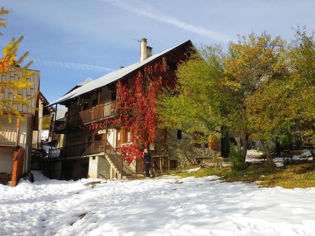 Un bâtiment avec du lierre rouge dans la neige dans l'établissement Gîtes Vallouise Ecrins, à Vallouise