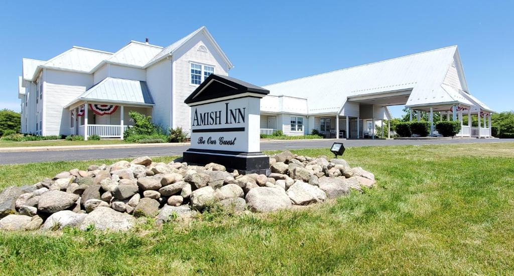 een bord in een stapel rotsen voor een gebouw bij Amish Inn in Nappanee