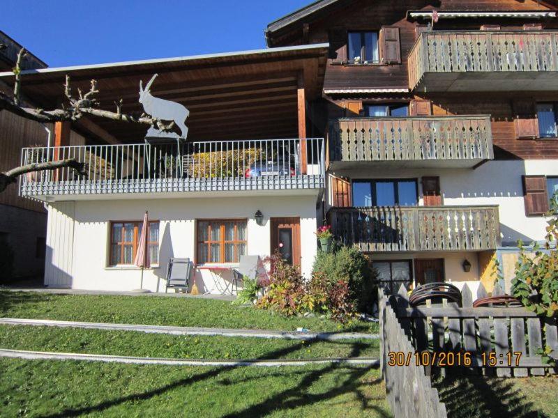 una casa con un cervo sul balcone di Flumina - Ferienwohnung für max. 4 Personen a Flims
