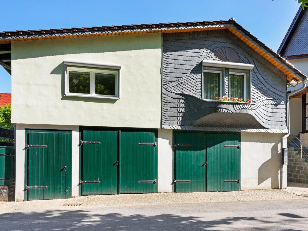 une maison avec des portes de garage vertes et une fresque murale dans l'établissement Attractive apartment in R beland in the Upper Harz, à Elbingerode