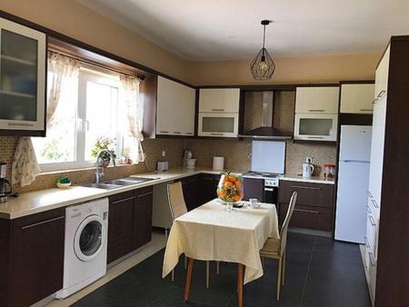 a kitchen with a table and a kitchen with a washing machine at La Vatura in Gialova