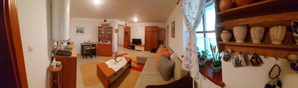 sala de estar con sofá y mesa en una habitación en Nyugalom szigete 2 fős apartman 1 hálótérrel, en Vértessomló