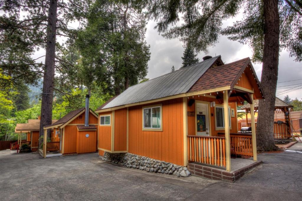 a small orange house with a black roof at Sleepy Hollow Cabins & Hotel in Crestline