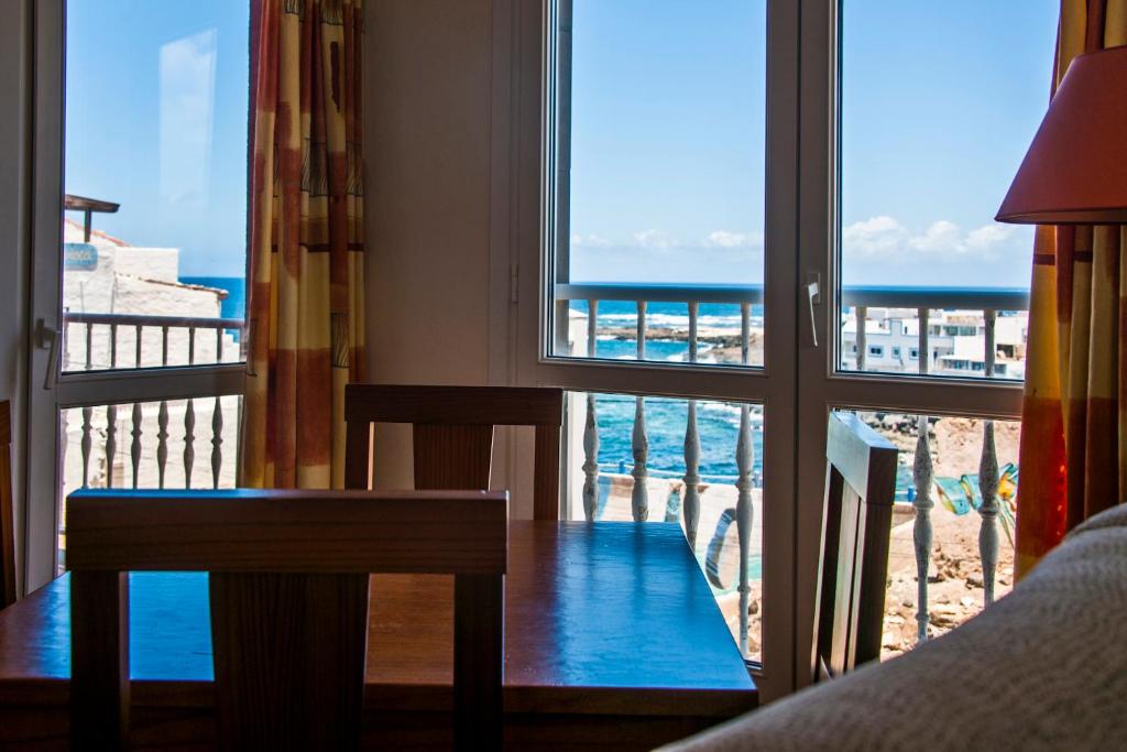 a room with a table and a view of the ocean at Holiday Apartment Casa Vista Mar Oliastur El Cotillo in Cotillo