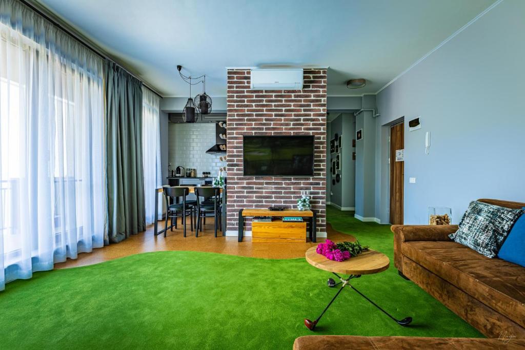 - un salon avec un canapé et un tapis vert dans l'établissement The Golfer Apartment with Jacuzzi, à Cluj-Napoca