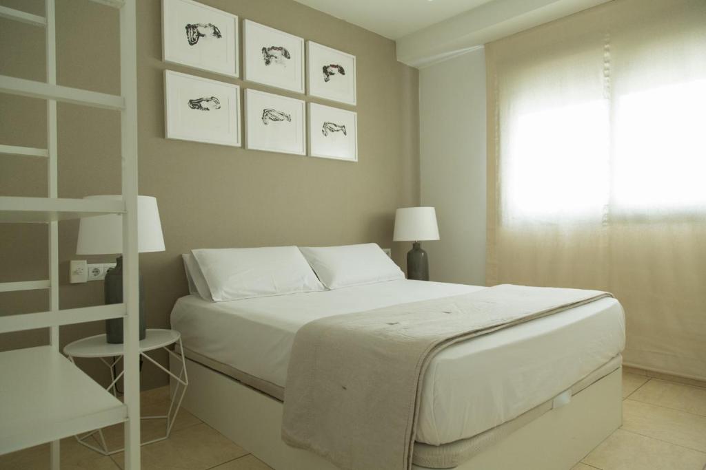 トレモリノスにあるApt Boutique - La Estrellaの白いベッドルーム(ベッド1台、窓付)