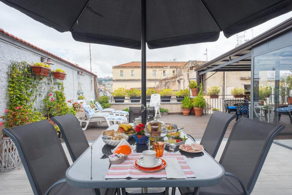 a table with food on a patio with an umbrella at La Terrazza ai Miracoli in Naples